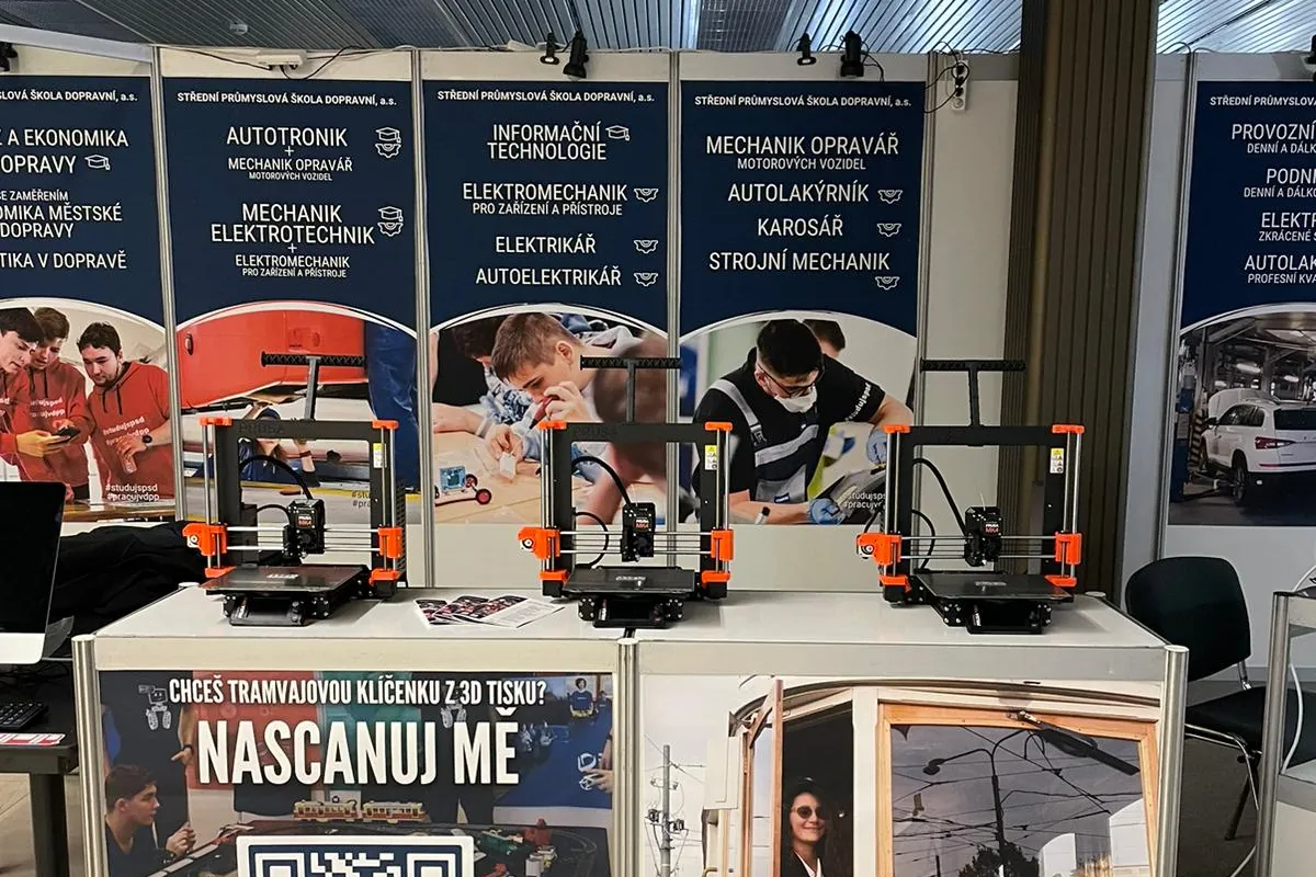 Stánek SPŠD na veletrhu Schola Pragensis s panely oborů a 3D tiskárnami